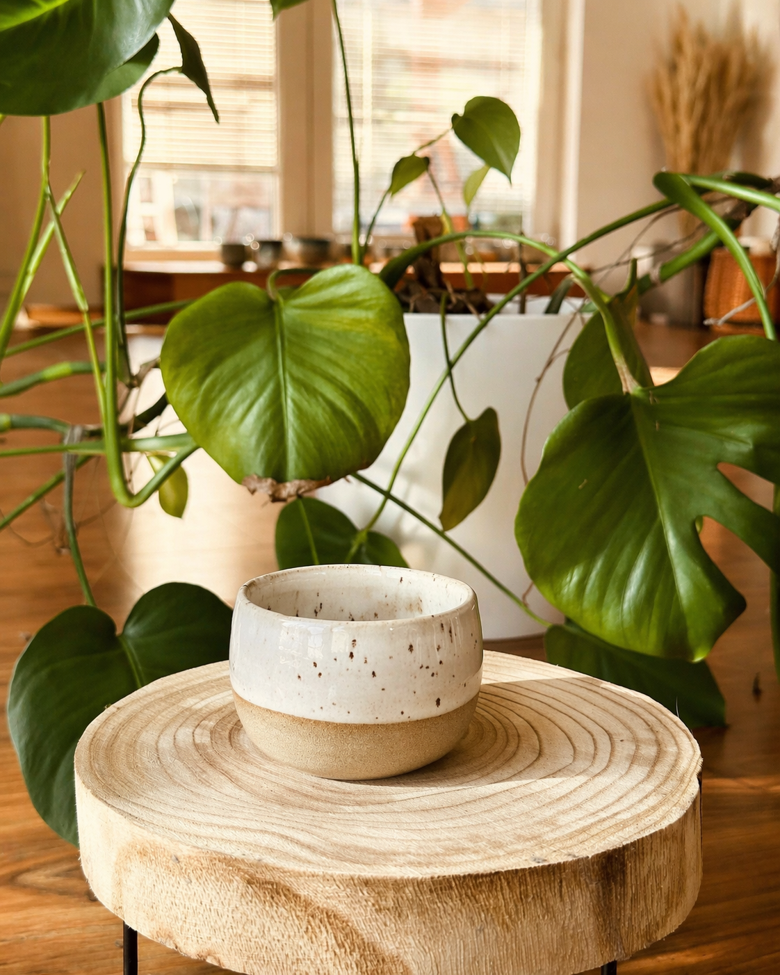 Detail zeleně žíhaného keramického kalíšku na dřevěné podložce